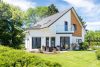Ein Einfamilienhaus mit Balkon, Terrasse und Garten.