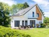 Ein Einfamilienhaus mit Balkon, Terrasse und Garten.
