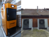 In einem Heizungsraum steht links eine Stückholzheizung des Produkttyps Easytronic XV und rechts sind zwei montierte Wärmepumpen an der Hausrückseite ersichtlich.